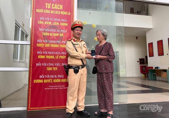 Đại úy Nguyễn Hồng Sơn, cán bộ Đội CSGT đường bộ số 14, bàn giao chiếc điện thoại cho chủ sở hữu.