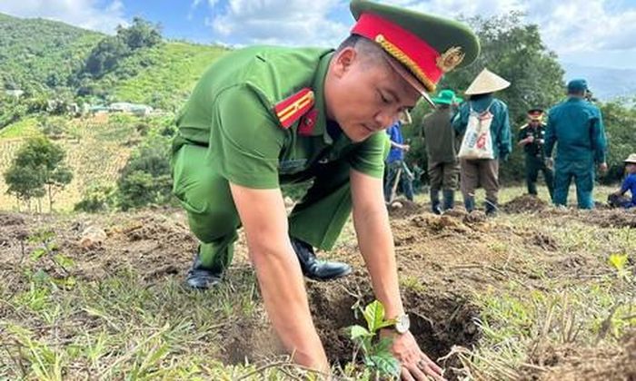 Thiếu tá Nguyễn Văn Hạnh - Trưởng Công an xã Tu Mơ Rông hỗ trợ trồng cây cà phê cho người dân.