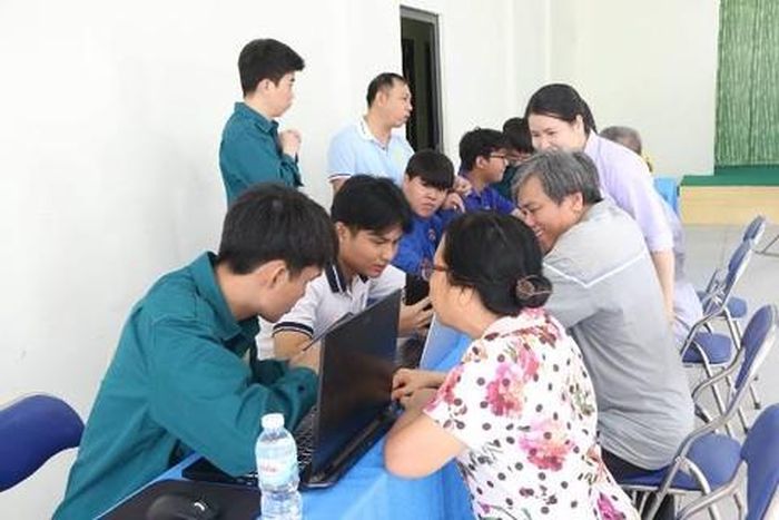 Đoàn viên thanh niên xã Hóc Môn hướng dẫn người dân thực hiện thao tác giải quyết thủ tục hành chính trực tuyến
