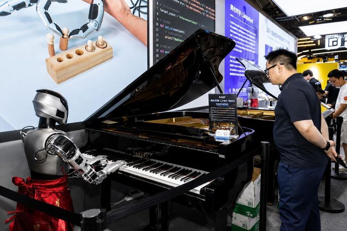 Một du khách xem robot chơi piano trong Hội nghị Trí tuệ Nhân tạo Thế giới 2026. (Ảnh: xinhua)