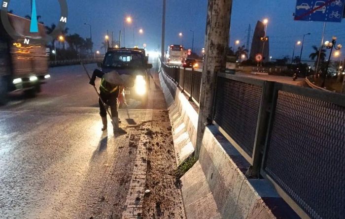 Sáng sớm, Công ty cổ phần Công trình đô thị Long Biên đã phải huy động công nhân dọn đất rơi vãi trên đường Võ Văn Kiệt (địa phận xã Thiên Lộc). Ảnh: Đức Duy
