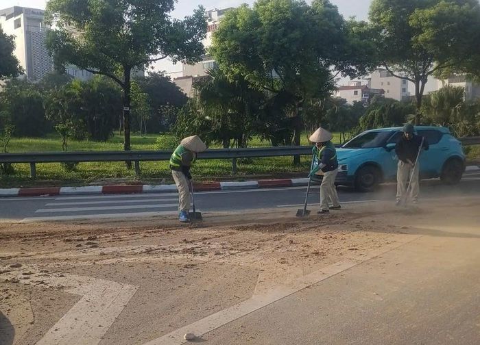 Công nhân Công ty cổ phần Công trình đô thị Long Biên vất vả thu dọn chất thải trên một số tuyến dường dẫn lên các cầu. Ảnh: Đức Duy
