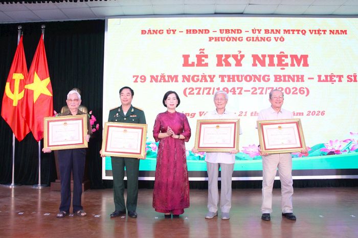 Phó Bí thư Thường trực Đảng ủy phường Giảng Võ Nguyễn Quế Anh trao tặng Huân chương Bảo vệ Tổ quốc cho 4 đồng chí. Ảnh: TT