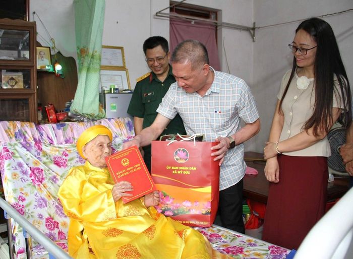 Chủ tịch UBND xã Nguyễn Quang Đường thăm Bà mẹ Việt Nam Anh hùng Dương Thị Hạt. Ảnh: Biên Phạm