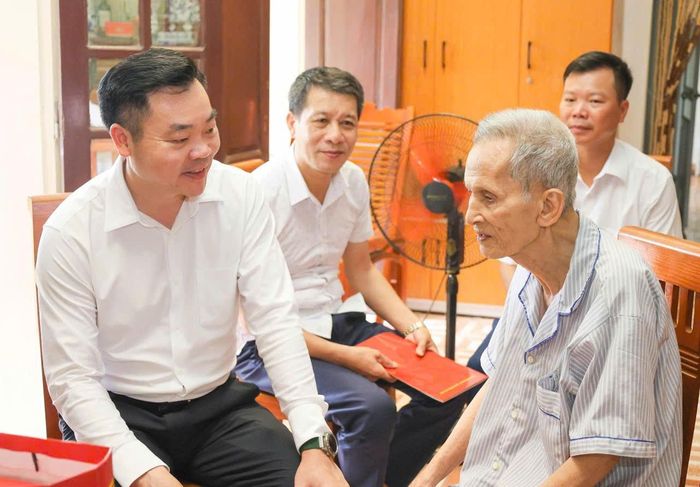 Bí thư Đảng ủy xã Đại Xuyên Đào Việt Long ân cần thăm hỏi các thương bệnh binh, người có công trên địa bàn xã. Ảnh: PV