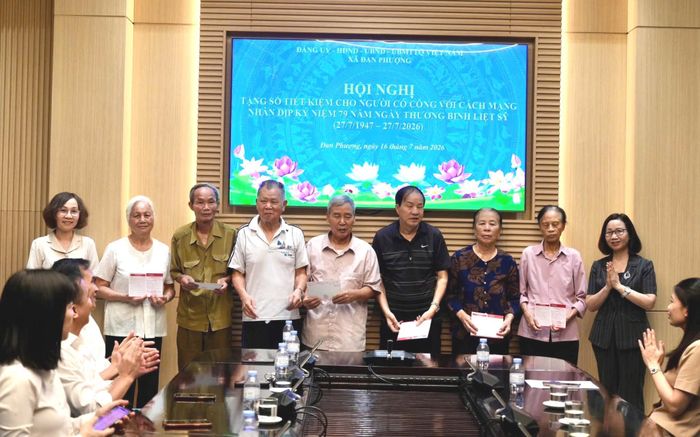Phó Bí thư Thường trực Đảng ủy xã Đan Phượng Nguyễn Thị Hiền và Chủ tịch Ủy ban Mặt trận Tổ quốc xã Nguyễn Thị Thủy tặng sổ tiết kiệm cho các gia đình chính sách. Ảnh: Ngân Nguyễn