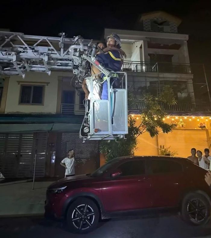 Người đàn ông có biểu hiện bất thường leo lên mái nhà 3 tầng tại phường Trường Vinh (Nghệ An) trước khi được lực lượng cảnh sát cứu nạn, cứu hộ đưa xuống an toàn tối 20/7. (Ảnh: Bạn đọc cung cấp)