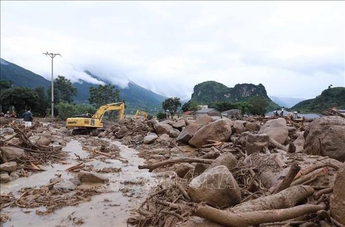 Máy móc khơi thông, uốn dòng chảy để nhanh chóng khắc phục giao thông trên tuyến Quốc lộ 32. Ảnh: Quý Trung/TTXVN