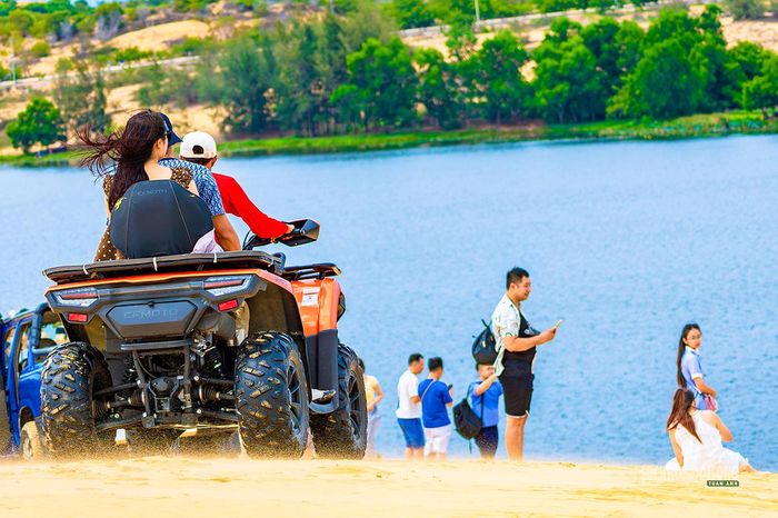 Du khách dừng xe trên đồi cát, hướng tầm mắt ra hồ Bàu Trắng. Ảnh: LN