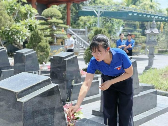 Một đoàn viên thanh niên đang sửa sang, dâng hương tại phần mộ các anh hùng liệt sĩ. Ảnh: TĐHT.
