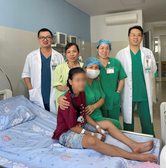 Trẻ hồi phục khỏe mạnh bên các bác sĩ, điều dưỡng và gia đình