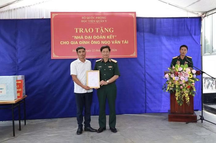 Thiếu tướng, Phó Giáo sư, Tiến sĩ Nguyễn Văn Nam, Phó Chính ủy Học viện Quân y trao Quyết định về việc hỗ trợ xây tặng “Nhà Đại đoàn kết” cho gia đình ông Ngọ Văn Tài.
