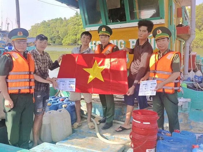 Bộ đội biên phòng Thành phố Hồ Chí Minh phát tờ rơi phòng, chống IUU và tặng cờ Tổ quốc cho ngư dân. (Ảnh: Lê Đình Thìn)