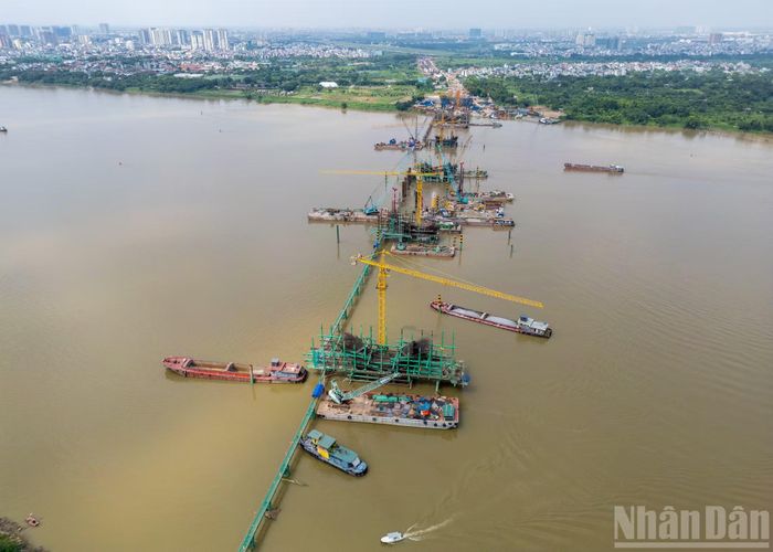 Việc thi công 5 trụ cầu chính giữa sông Hồng là hạng mục quan trọng và phức tạp nhất khi phải chạy đua thời gian để sớm hoàn thiện trước mùa mưa lũ tới. Sau nhiều tháng tập trung xử lý nền móng dưới lòng sông, nhiều trụ cầu đã vươn lên khỏi mặt nước.