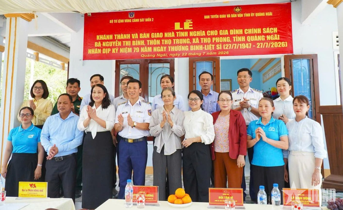 Các đại biểu thực hiện nghi thức cắt băng khánh thành Nhà tình nghĩa và chụp ảnh lưu niệm.