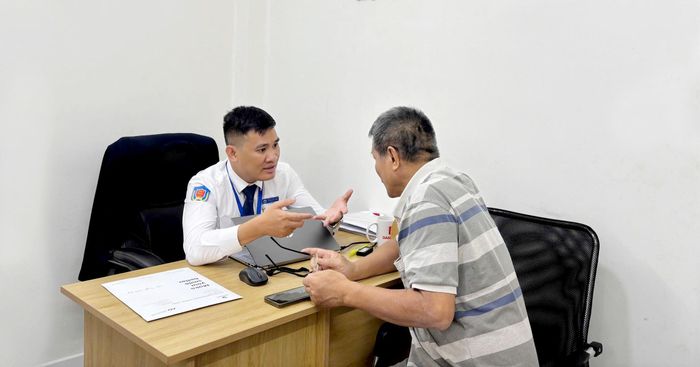 Thừa hành viên trao đổi công việc với khách hàng. ẢNH: SONG MAI