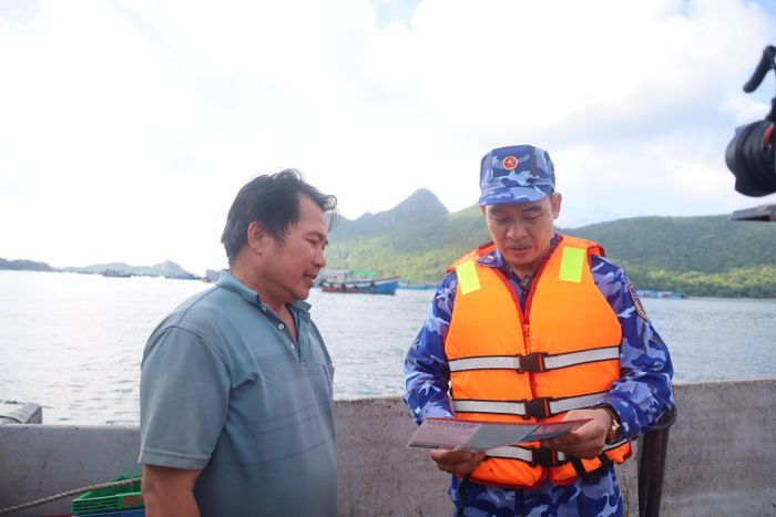 Lực lượng Cảnh sát biển trực tiếp tuyên truyền, phổ biến Luật Thủy sản, Luật Cảnh sát biển Việt Nam cho các chủ tàu ngay trên biển. Ảnh: QUỐC HÙNG