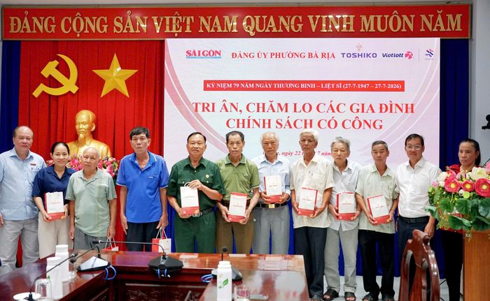 Phó Giám đốc Thường trực Trung tâm Dịch vụ Truyền thông - Sự kiện Báo SGGP Vũ Anh Tuấn (bìa trái) và Phó Chánh Văn phòng Đảng ủy phường Bà Rịa Nguyễn Chí Cường (thứ 2 bên phải) trao máy đo huyết áp cho người có công. Ảnh: VIỆT NGA