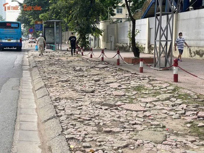 Khu vực điểm dừng xe buýt trước Bệnh viện Quân y 103 có mặt vỉa hè gồ ghề, khiến hành khách phải lựa chọn vị trí bằng phẳng để đứng chờ xe.