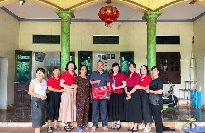 Bà Hồ Thị Lệ - Hiệu trưởng Trường THCS Vĩnh Lại (thứ tư từ phải sang) đại diện nhà trường tặng quà gia đình chính sách là người thân của cán bộ, giáo viên nhân viên nhà trường.
