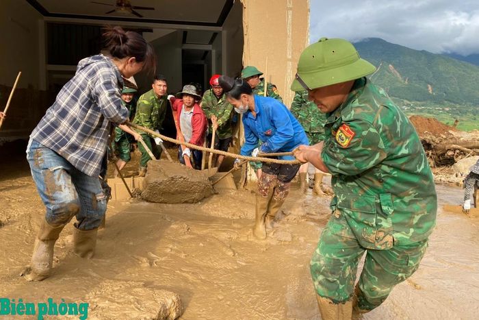 Cán bộ, chiến sĩ Bộ đội Biên phòng phối hợp với các lực lượng và người dân di chuyển khối bê tông, dọn bùn đất tại ngôi nhà bị lũ quét vùi lấp ở xã Mường Than. Ảnh: Văn Hợi