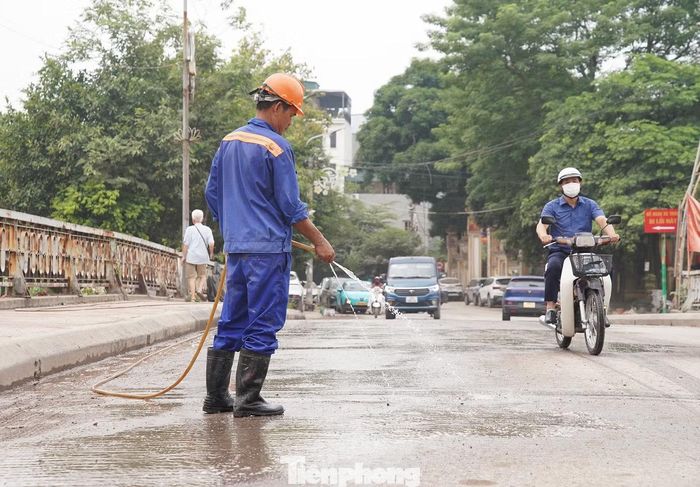 Công nhân phun nước để giảm bụi cho các tuyến đường xung quanh dự án