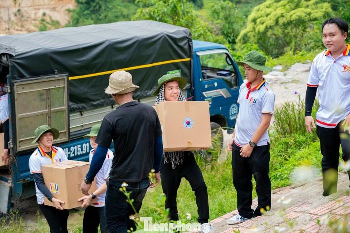 Những chiến sĩ tình nguyện của Trường Đại học Công nghệ thông tin và Truyền thông Việt - Hàn (Đại học Đà Nẵng) đã vượt hơn 100 km để đến với người dân thôn Long Túc, xã Trà Linh. Hành trang mang theo là những phần quà góp phần đổi thay cuộc sống của bà con. Ảnh: T.H.
