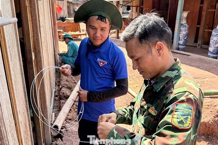  Trong lúc bà cùng người thân thu dọn những vật dụng cuối cùng, các tình nguyện viên đã nhanh chóng chằng cột căn nhà gỗ, chuẩn bị di chuyển sang vị trí mới. "Được bố trí tái định cư, tôi bớt lo lắng khi mùa mưa bão sắp tới. Có các bạn tình nguyện viên hỗ trợ nên việc di chuyển nhà cửa, tài sản cũng đỡ vất vả hơn", bà Nhoom chia sẻ. 