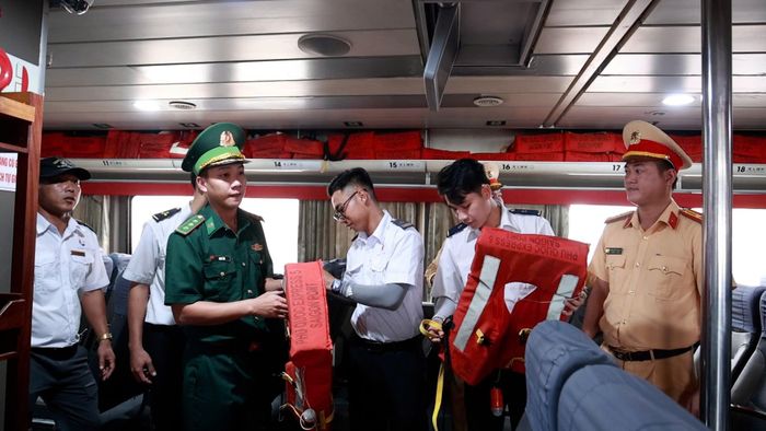 Hướng dẫn du khách mặc áo phao khi lên tàu ra đảo Lý Sơn nhằm đảm bảo an toàn.