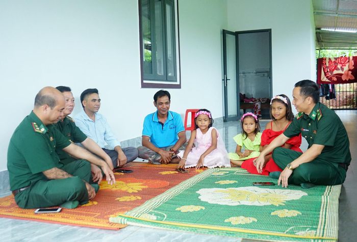 Ông Bíu (thứ 3 từ trái qua) trở thành thôn trưởng, cùng lực lượng Bộ đội Biên phòng tuyên truyền pháp luật đến người dân. Ảnh: Ngọc Thu