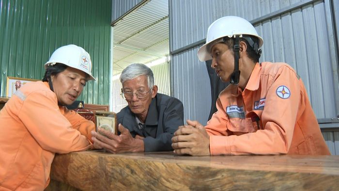 Nhân viên Điện lực Cư Jút hướng dẫn người dân xã Đắk Wil sử dụng ứng dụng EVN CSKH trên điện thoại thông minh