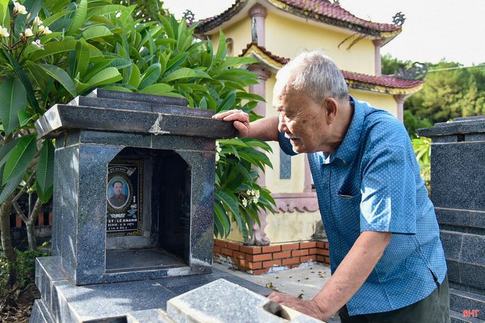 Ông Lê Khắc Mão bên những tấm huân, huy chương và phần mộ của 2 người anh là liệt sỹ Lê Khanh và liệt sỹ Lê Duy Trí.