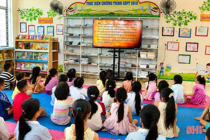 Các em học sinh Trường Tiểu học Tượng Sơn xem lại những thước phim trong chương trình Truyền hình trực tiếp "Vang mãi khúc quân hành".