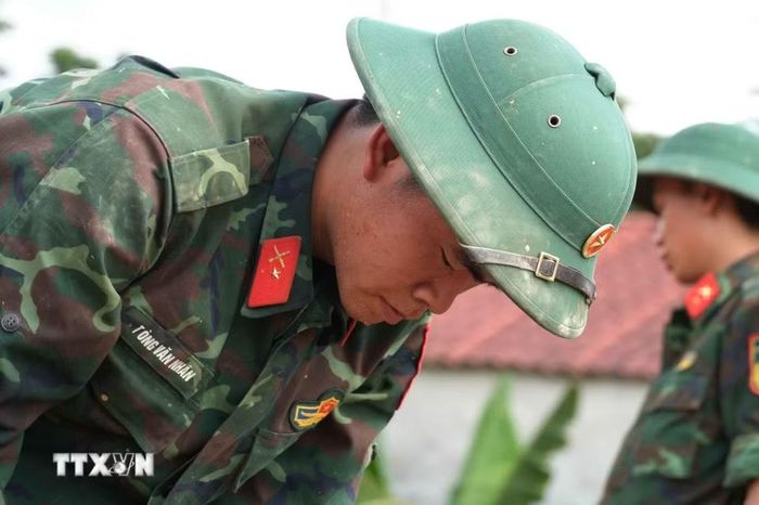 Khuôn mặt đen sạm của chiến sỹ Tòng Văn Nhân sau bao ngày dầm mưa, phơi nắng giúp dân vùng lũ Mường Than. (Ảnh: Nguyễn Oanh/TTXVN)