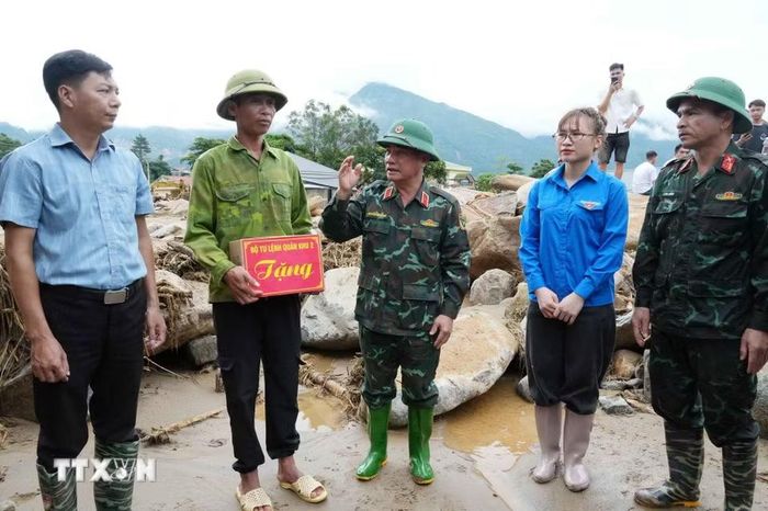 Thiếu tướng Nguyễn Đăng Khải, Phó Tư lệnh tham mưu trưởng Quân khu 2 chia sẻ những mất mát với các gia đình ở tại xã Mường Than. (Ảnh: Nguyễn Oanh/TTXVN)