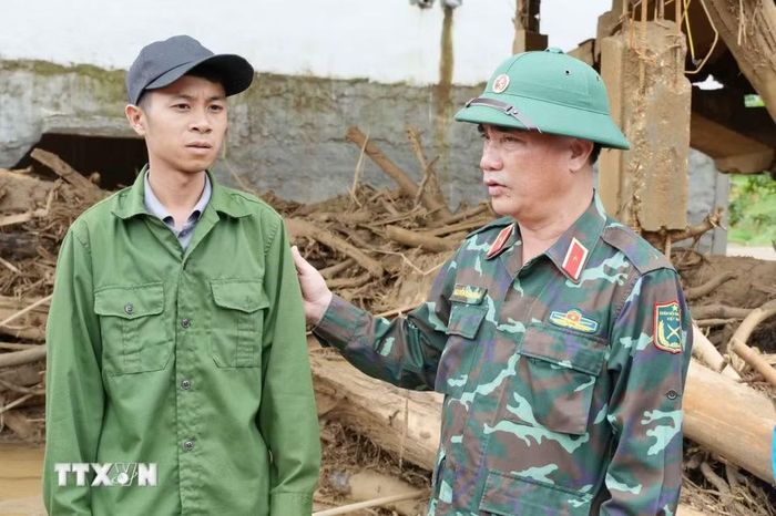 Thiếu tướng Nguyễn Đăng Khải, Phó Tư lệnh tham mưu trưởng Quân khu 2, chia sẻ những mất mát với các gia đình ở tại xã Mường Than. (Ảnh: Nguyễn Oanh/TTXVN)