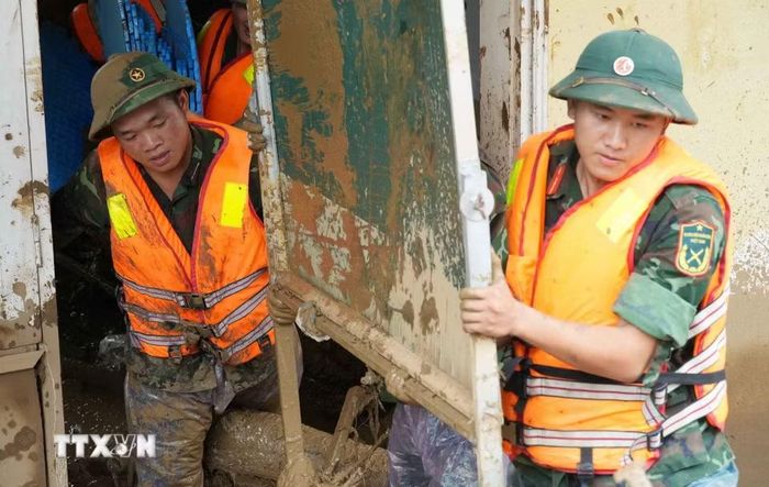 Tại tâm lũ Mường Than, bộ đội làm việc với tinh thần "Còn dân là còn tất cả". (Ảnh: Nguyễn Oanh/TTXVN)