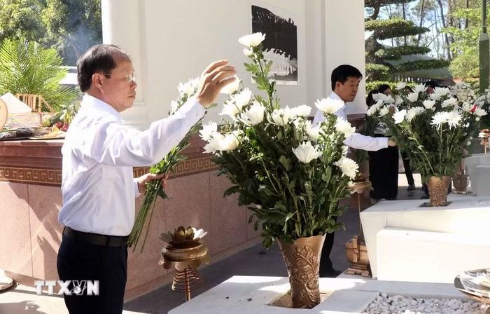 Du khách dâng hoa tại khu mộ 10 nữ liệt sỹ Thanh niên xung phong Ngã ba Đồng Lộc. (Ảnh: Công Tường/TTXVN)