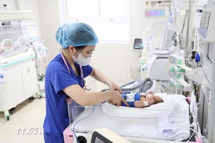 Nhân viên y tế chăm sóc cho trẻ sơ sinh. (Ảnh: TTXVN phát)