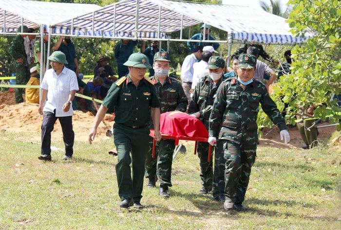 Các lực lượng đưa hài cốt các liệt sỹ được quy tập về tập kết tại khu vực lấy mẫu sinh phẩm. (Ảnh: Hồng Hiếu/TTXVN)