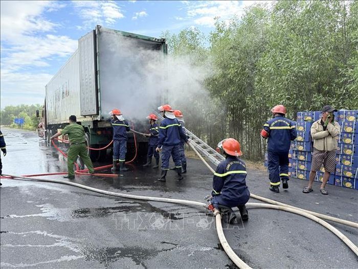Các lực lượng chức năng phun nước dập tắt ngọn lửa trên chiếc container bị cháy. Ảnh: TTXVN phát