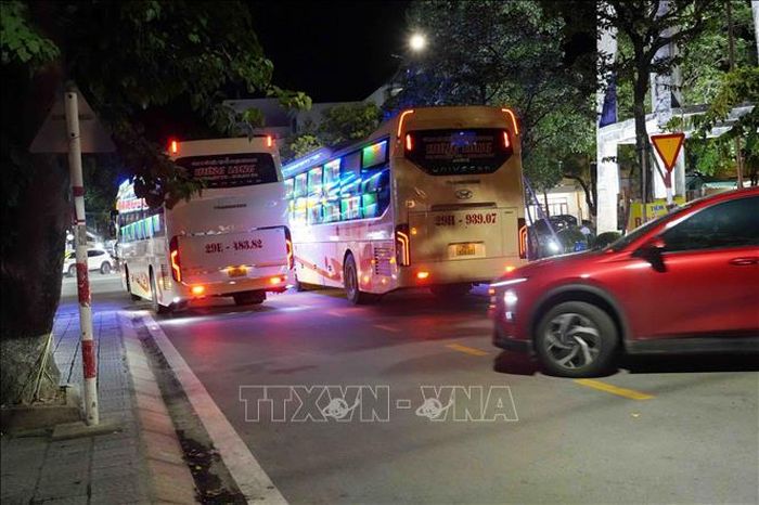 Tuyến đường Bà Huyện Thanh Quan nhỏ, lưu lượng người đông nhưng xe khách Công ty Cổ phần Vận tải du lịch Hưng Long vẫn thường xuyên dừng, đỗ, đón khách và bốc xếp hàng hóa. Ảnh: Tá Chuyên/TTXVN