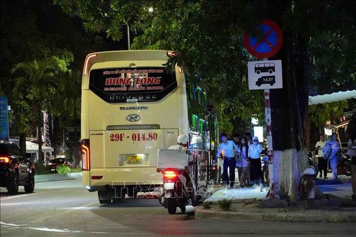 Mặc dù tại đây đã lắp đặt biển báo cấm dừng đỗ, nhiều phương tiện của Công ty Cổ phần Vận tải du lịch Hưng Long vẫn dừng để đón, trả khách và bốc xếp hàng hóa. Ảnh: Tá Chuyên/TTXVN