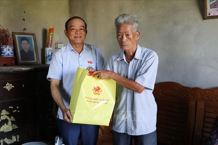 Đồng chí Lã Thanh Tân tặng quà ông Nguyễn Xuân Tài trú tại thôn Đại Hợp, xã Tân Kỳ là người hoạt động kháng chiến bị nhiễm chất độc hóa học, tỷ lệ thương tật 61%. Ảnh: Mạnh Minh/TTXVN