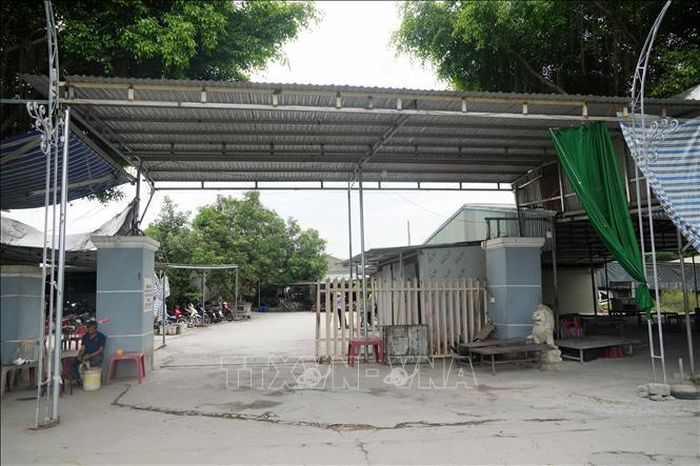 Trên diện tích khoảng 1.300 m2, gia đình ông Nguyễn Bình Minh dựng khung sắt, lợp mái tôn tạm để sinh hoạt chợ và nhận trông xe cho công nhân của công ty bên cạnh. Ảnh: Việt Hoàng/TTXVN