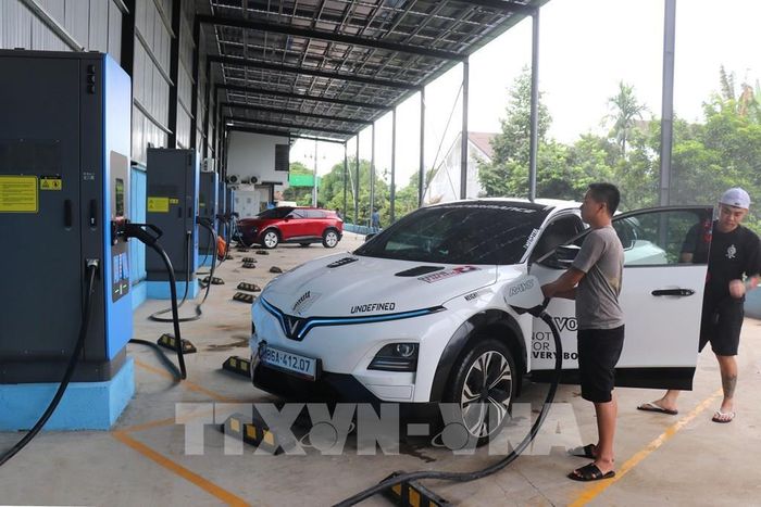Sạc điện cho ô tô tại Công ty TNHH Green Charge LC, tại xã Cư Jút, tỉnh Lâm Đồng với hệ thống điện mặt trời mái nhà (phía trên) có tổng công suất 123 KWp. Ảnh: Thanh Vũ – TTXVN 
