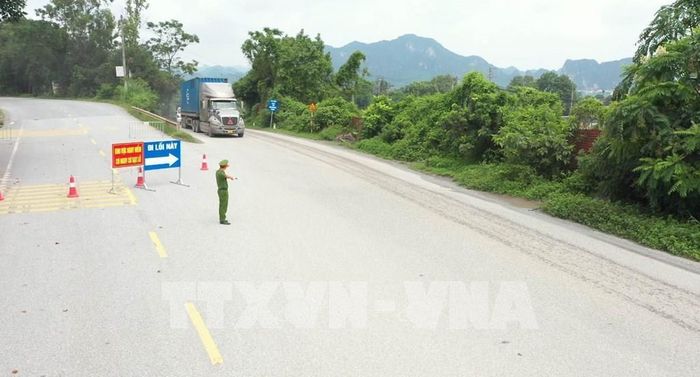 Công an phường Tam Chúc hướng dẫn các phương tiện chuyển hướng di chuyển qua đoạn đường song hành Quốc lộ 21A nhằm đảm bảo an toàn. Ảnh: Hải Yến - TTXVN 