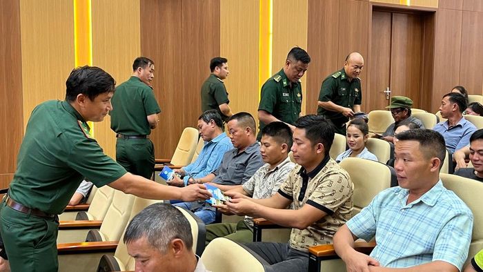 Bộ đội biên phòng phát tờ rơi tuyên truyền đến người dân tham gia chương trình truyền thông.