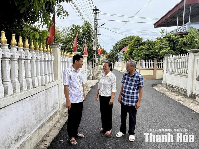 Anh Nguyễn Văn Hoài (bên trái) vận động Nhân dân hiến đất mở rộng đường giao thông.