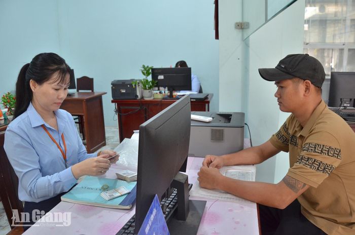Công chức Trung tâm Phục vụ hành chính công xã Sơn Kiên hướng dẫn người dân thực hiện các thủ tục hành chính. Ảnh: VĨ AN